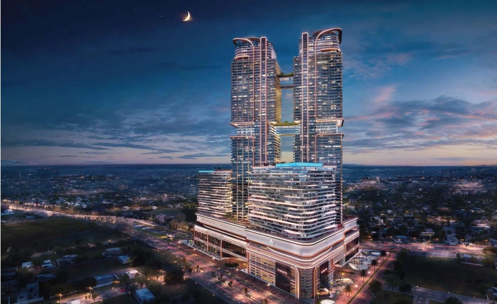 Burj Quaid twin towers at dusk with Adidas flagship retail signage at podium level